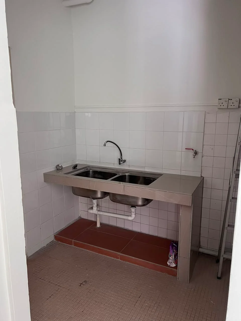 Laundry features: double-bowl stainless-steel sink, chrome pull-down faucet, white tiled walls, red tiled flooring, exposed plumbing, wall-mounted faucet, shelf for storage, clean and minimalistic design; style: modern.